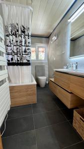 a bathroom with a tub and a toilet and a sink at Chalet La Louise avec vue imprenable in Crans-Montana