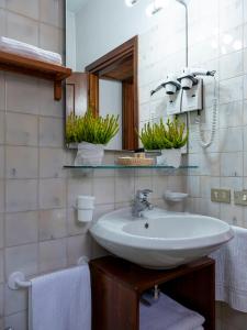 a bathroom with a sink and a mirror and towels at Residence Cima Jazzi in Macugnaga