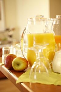 a glass pitcher of orange juice and apples on a table at Radisson Hotel Dusseldorf City Center in Düsseldorf