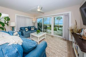 sala de estar con sofá azul y mesa en Beachfront Aldea 13, en Clearwater Beach