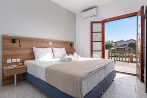 een slaapkamer met een groot bed en een balkon bij Eleon Suites & Apartments in Afitos +34 foto's