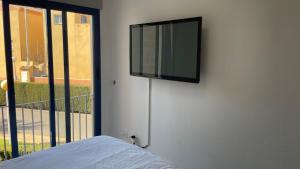a flat screen tv on a wall next to a window at Cabo Roig - Blue Luxury Apartment in Cabo Roig +58 photos