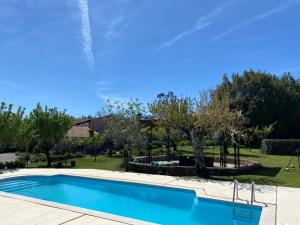 una piscina azul en un patio con árboles en Quinta das Eiras, en Penela