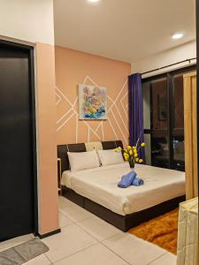 ein Schlafzimmer mit einem Bett mit einer Blumenvase in der Unterkunft Jazz family homestay in Jelutong