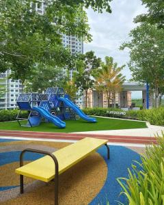 einen Park mit einer Bank und einem Spielplatz mit Rutschen in der Unterkunft Jazz family homestay in Jelutong