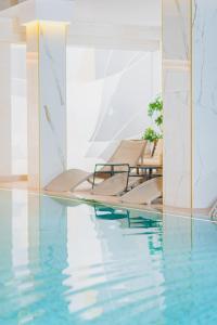 a pool with blue water and two lounge chairs at Stay inn Hotel Warszawa in Warsaw