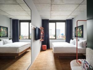 una camera d'albergo con due letti e uno specchio di URBAN LOFT Berlin a Berlino