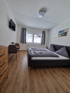 a bedroom with a bed and a table and a chair at Pension Bergfried in Hallstatt