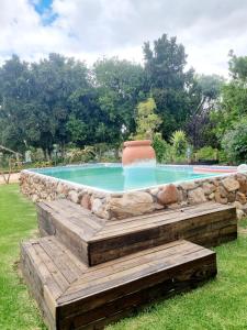 una piscina con una pared de piedra y una fuente. en Angel 8 AirBnB Apartment 1, en Robertson