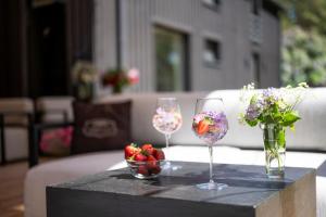 dos copas de vino y un tazón de fresas sobre una mesa en Hõbekala Guesthouse en Kalana
