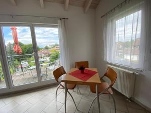 a dining room with a table and chairs and a balcony at Haus Lorenz, Ferienwohnungen in Immenstaad am Bodensee