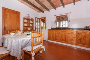 a kitchen with a table and wooden cabinets at Villa Vilar by Sealand Villas in El Port