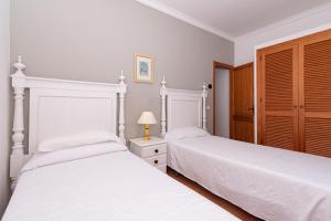 two beds in a bedroom with white walls at Villa Vilar by Sealand Villas in El Port +17 photos