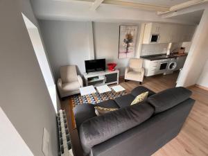 a living room with a couch and a kitchen at Apartamento Bolingas in Comillas