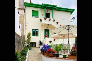 a house with an umbrella and flowers in front of it at Apartamento Bolingas in Comillas