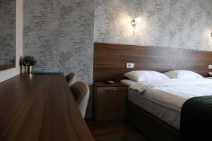 a bedroom with a bed and a wooden headboard at Hotel Garden in Novi Sad