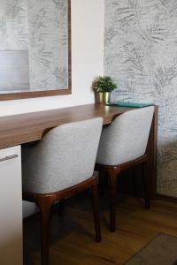 a desk with two chairs and a plant on it at Hotel Garden in Novi Sad