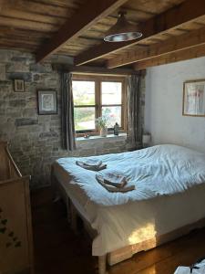 a bedroom with a large bed in a brick wall at The Cartshed in Osmington