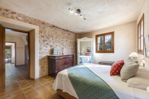 a bedroom with a bed and a dresser at Finca Som Llum in Palma de Mallorca +21 photos