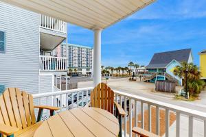 een balkon met een tafel en stoelen en een gebouw bij Seaside Unit C in Myrtle Beach