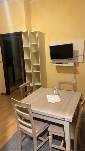 une salle à manger avec une table, des chaises et une télévision dans l'établissement CASA GEMELLI GEMELLI, à Rome