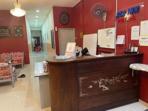 a restaurant with a counter in a room with red walls at SZA INN HOTEL in Kampong Kerayong