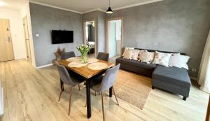 a living room with a couch and a table with chairs at Przytulna Apartment close to the airport and PKM in Gdańsk