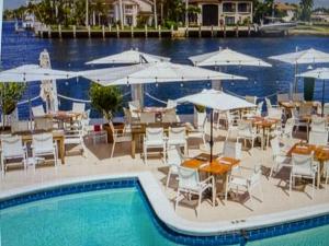 a swimming pool with tables and chairs and umbrellas at Delightful 2 Bdrm Sport Yacht with Pool in Pompano Beach
