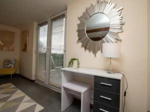 a bathroom with a mirror and a desk with a lamp at Pass the Keys Large Family House near Lincoln in North Hykeham