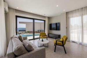 a living room with a couch and chairs and a tv at Modern villa Luce with sea view in Peljesac in Trstenik
