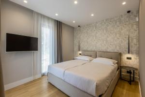 a bedroom with a large bed and a flat screen tv at Modern villa Luce with sea view in Peljesac in Trstenik +50 photos
