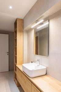 a bathroom with a white sink and a mirror at SKG Cityscape Metropolis in Thessaloniki