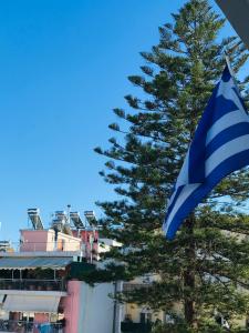 a blue and white flag next to a tree at Central Family Apartment in Preveza