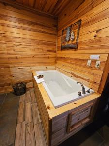 une baignoire jacuzzi dans une pièce en bois dans l'établissement Honey Bear Haven Suite 1, à Eureka Springs