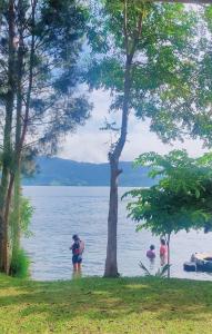 a group of people standing in the water at Sarah's Cottage Toba Samosir in Tuktuk Siadong