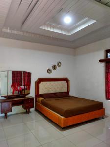 Schlafzimmer mit einem Bett, einer Kommode und einem Spiegel in der Unterkunft Sarah's Cottage Toba Samosir in Tuk Tuk