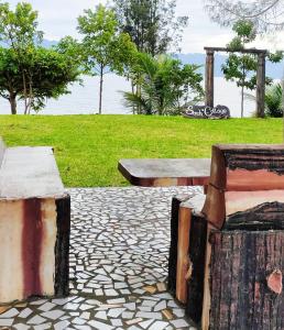 a painting of two benches and a park at Sarah's Cottage Toba Samosir in Tuktuk Siadong
