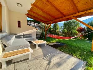 a patio with a couch and a hammock in a yard at Ferienwohnung Martina in Schlitters