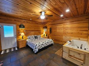 a bedroom with a bed and a bath tub at Honey Bear Haven Suite 1 in Eureka Springs