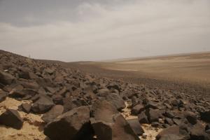 un gran grupo de rocas en un campo en St.Jadoor Inn, en Al Azraq ash Shamālī