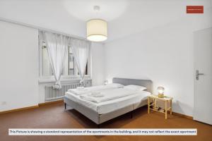 a white bedroom with a bed and a window at Spacious Apartment in Zurich in Zürich