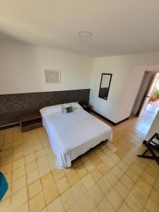 a bedroom with a white bed in a room at Hotel Gimaura in Ríohacha