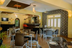 a restaurant with tables and chairs and a bar at Carina Beach Resort - 10mins walk to Benaulim Beach in Benaulim