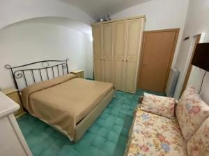 een kleine slaapkamer met een bed en een bank bij Casa Sissy in Vietri