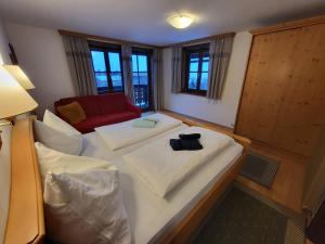 a room with two beds and a red couch at Schütterhof in Ramsau am Dachstein