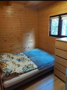 a bedroom with a bed in a log cabin at Domki Letniskowe 777 in Karwia