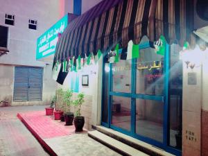 a store front with a blue and green awning at Everest Hotel Apartments in Sharjah