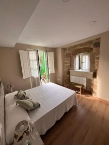 um quarto com uma grande cama branca num quarto em Casa Bolingas - Apto 5 em Comillas