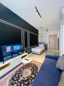a living room with a blue couch and a flat screen tv at AXON RESIDENCE AT BUKIT BiNTANG KUALA LAMPUR in Kuala Lumpur