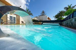 a swimming pool with a water fountain at La Cataleya in San Agustin